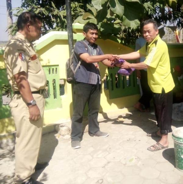 Wartawan Majalah FAKTA, Eko Purnomo, menerima titipan daging korban dari Guru Agama SMPN 1 Trucuk disaksikan Kepala Sekolah Drs Sarwo Edi.