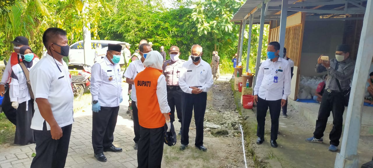 Bupati Bojonegoro pakai rompi oranye saat menitipkan pesan untuk warga kepada Kades Sugihwaras, Supandi (pakai masker hijau bersarung tangan).
