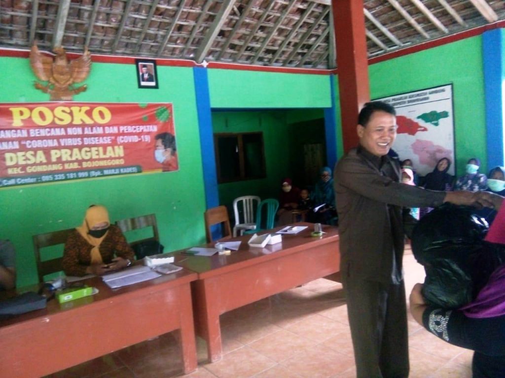 Kades Pragelan, Marji, saat menyerahkan sembako untuk warganya yang kena dampak Covid-19 (diseleksi yang paling layak mendapatkan).