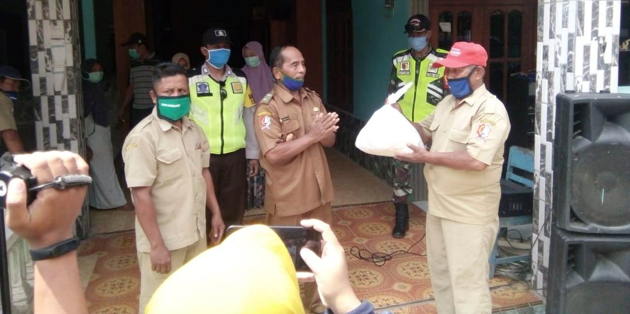 Kades Sumberagung, H Abdul Manan (Mbah Kung Haji Manan), ketika menyerahkan bantuan sembako secara simbolis kepada perangkatnya untuk dilanjutkan ke masing-masing rumah warga.